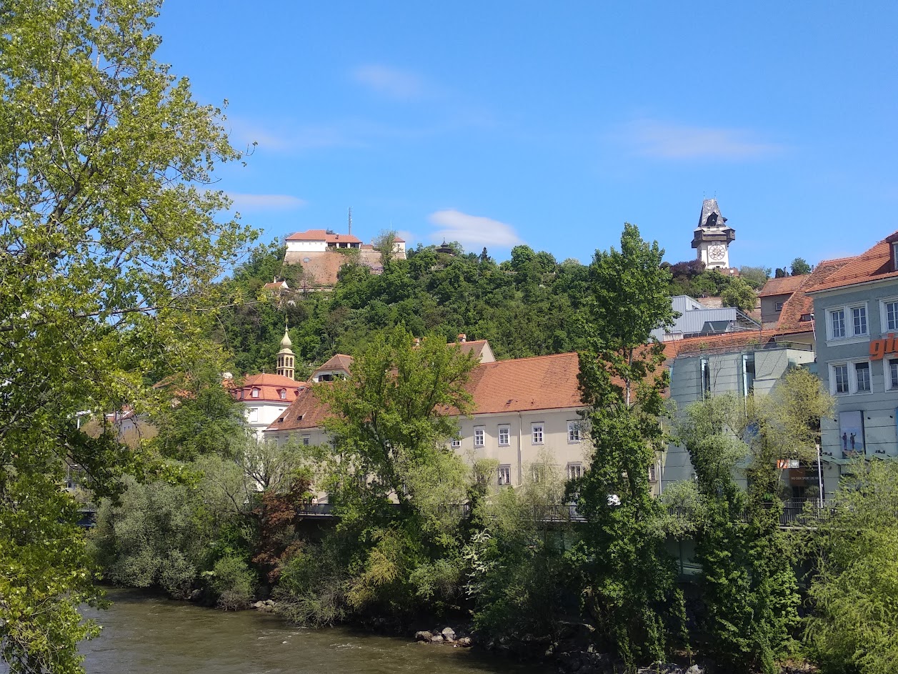 A photo of the Schlossberg in Graz shot from a bridge across the Mur